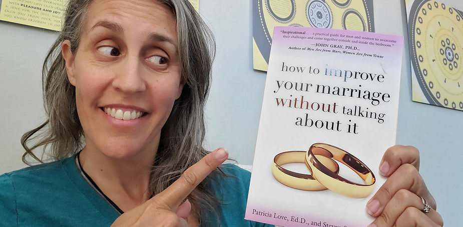 The author is smiling and pointing to the book she recommends in this post
